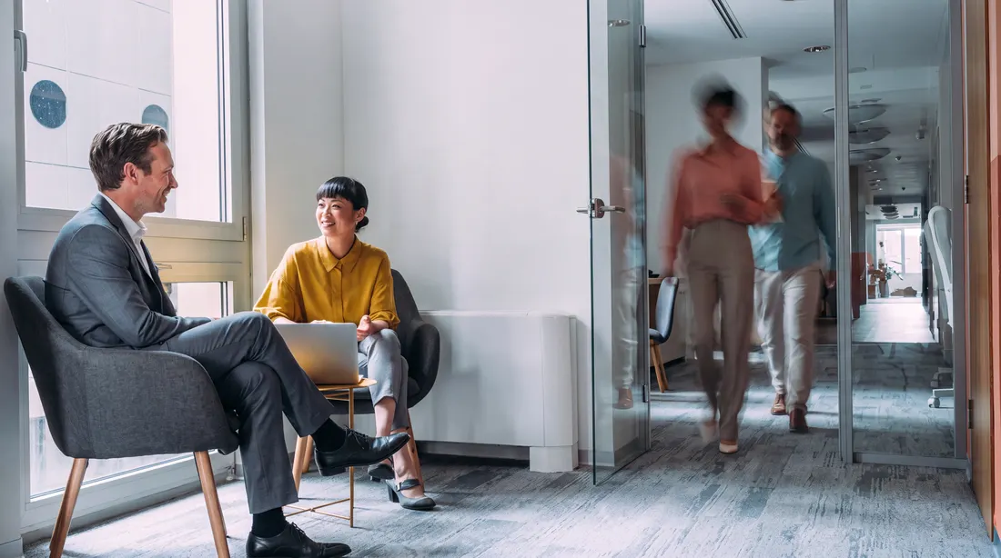Collega’s in gesprek bij de entree van een kantoor